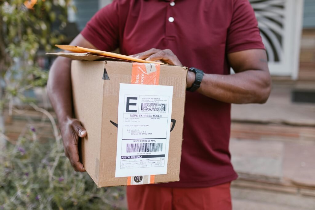 Close-up of a courier delivering a parcel with USPS express mail label outdoors.